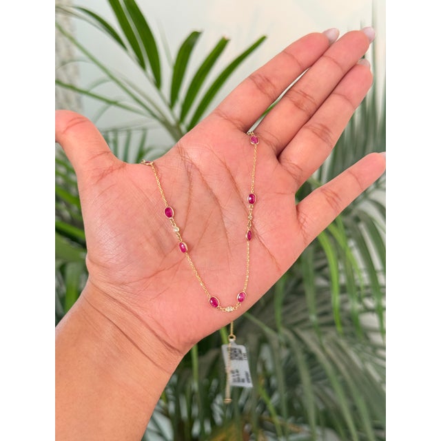 This station necklace features a 3.95 carats of natural oval-cut rubies, set in 14k yellow gold. . Each ruby measures...