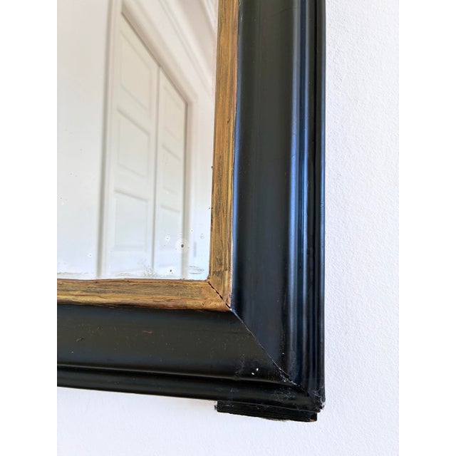 Antique French Louis Philippe mirror, dating to the late 19th century. The mirror with mercury glass features a black-...