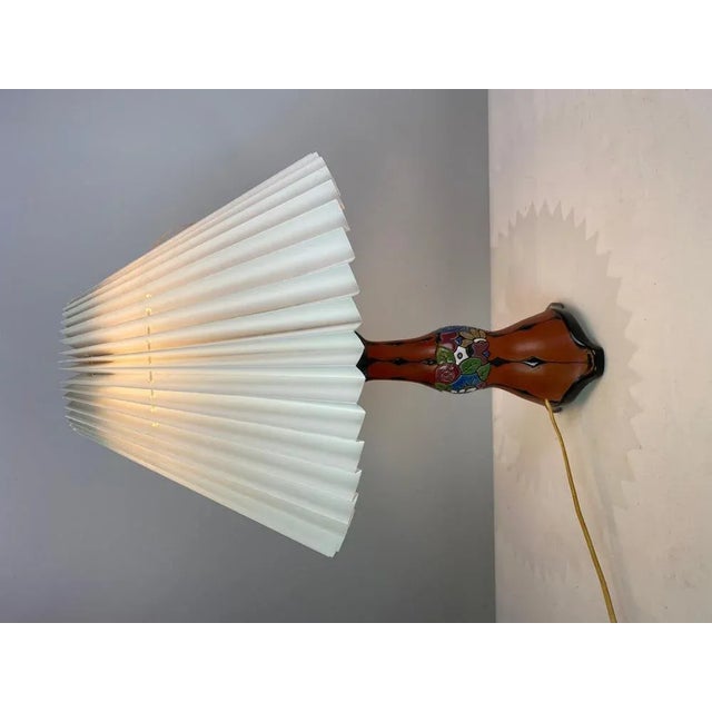 Ceramic table lamp with an orange glaze and with paper shade, from the 1960s. The lamp is with number 15436 and in great...