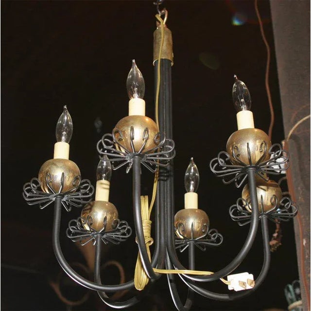 Small six-arm black metal and brass chandelier featuring brass ball and curlicue bobeches. Priced as one. Two are available.