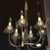 Small six-arm black metal and brass chandelier featuring brass ball and curlicue bobeches. Priced as one. Two are available.