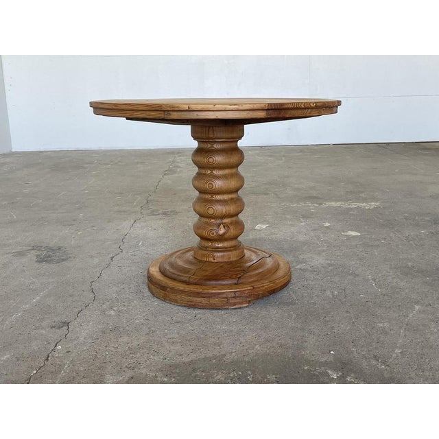 A striking and sculptural round pine pedestal dining table produced by a skilled Danish cabinetmaker in the 1970s — a...