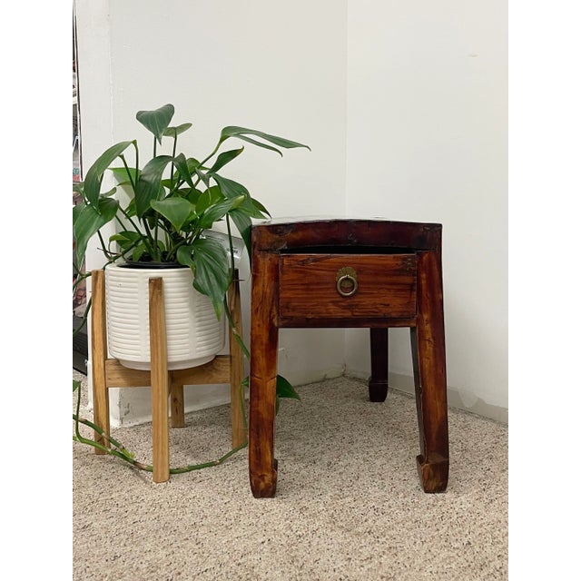 This vintage accent table is crafted in the style of traditional Chinese furniture, featuring a warm distressed elm wood...