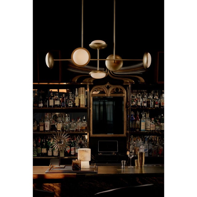 The Bond Chandelier finds harmony between form and function, simplicity and detail. Cushion-shaped opal glass diffusers...