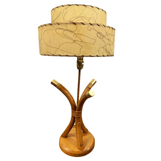 Restored pair of three-strand scalloped rattan bent pole table lamps on a mahogany base with brass center rob and...