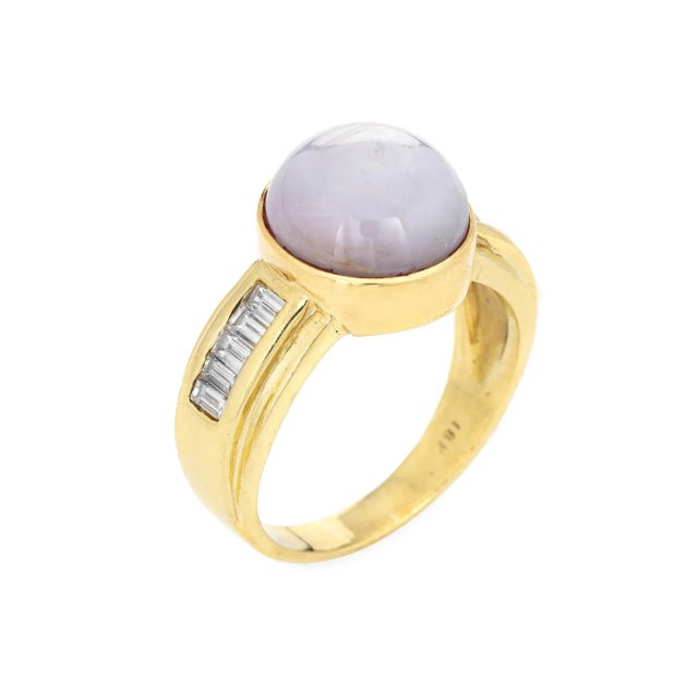 Stylish vintage natural star sapphire 7 diamond ring (circa 1980s to 1990s) crafted in 18 karat yellow gold. Cabochon cut...