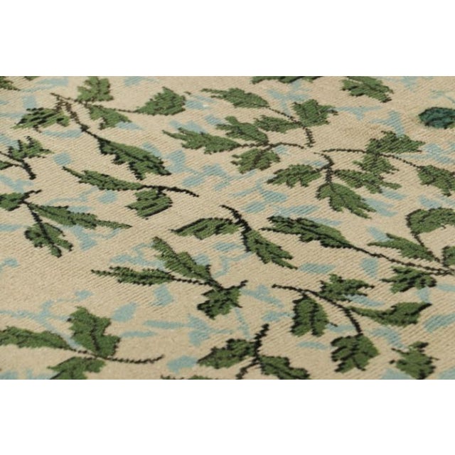 Hand-knotted in wool, circa 1960-1970, this 4x7 vintage Zeki Múren rug in beige features floral patterns in green and blue...