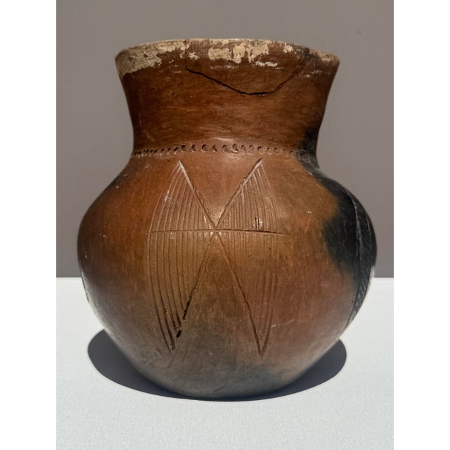 A sculptural hand-built earthenware vessel, traditionally formed using coil and paddle techniques and smoke-fired to...