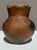 A sculptural hand-built earthenware vessel, traditionally formed using coil and paddle techniques and smoke-fired to...