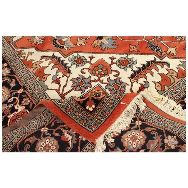 Handwoven Vintage Persian Heriz rug featuring a diamond shaped medallion is surrounded by rust color field with palmettes...
