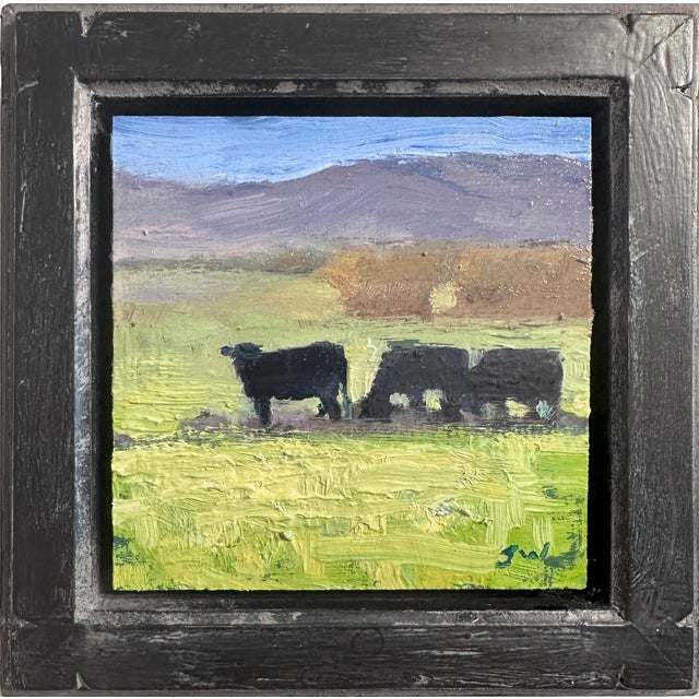 This oil on panel artwork depicts a serene rural scene featuring three cows grazing in a lush green field, set against a...