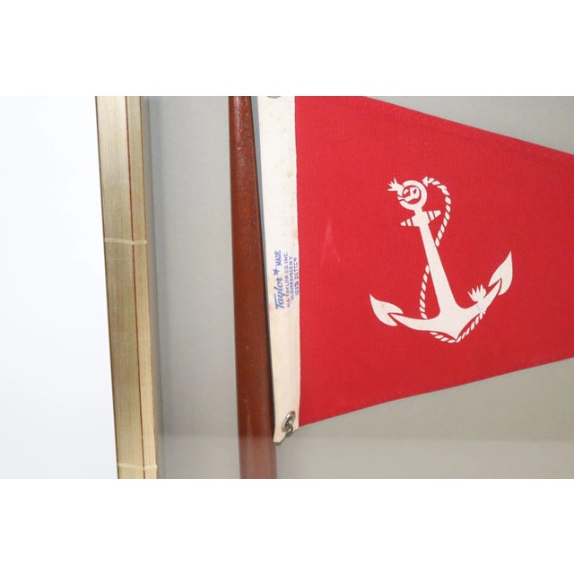 Framed nautical pennant on mast with a red field and white fouled anchor by Taylor. Fitted to a custom shadow box. Weight...