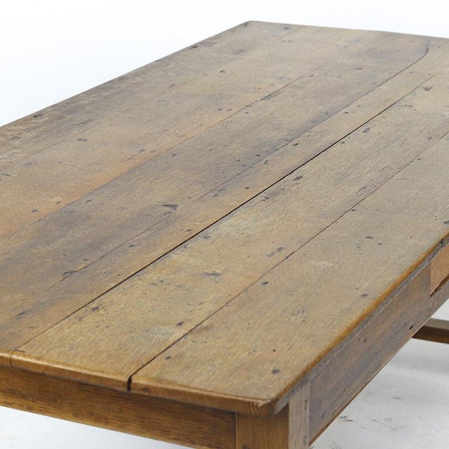 This rustic French dining table dates from around 1910 and is crafted from oak with a warm, natural color and a...