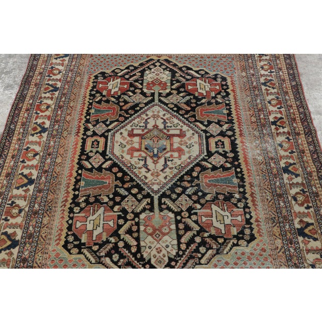 Hand-knotted in wool, this 5x7 antique Qashqai rug from Persia dates to circa 1890–1900. A refined example of tribal...
