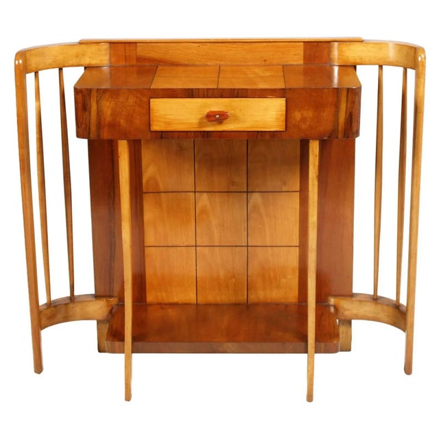 This art deco console with a mirror is made of walnut, solid maple, and maple veneer. The design is reminiscent of works...