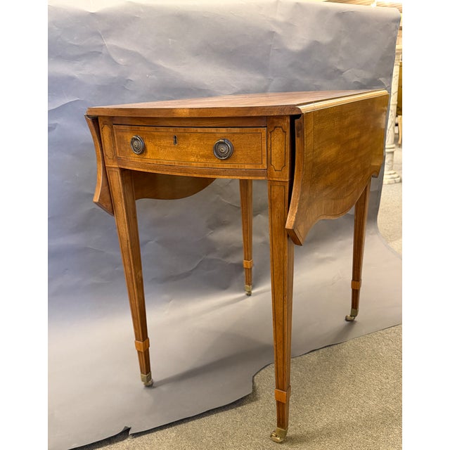 Pair of English Pembroke Tables, circa 1920s, crafted in rich mahogany with elegant satinwood, ebony, and tulipwood inlay....