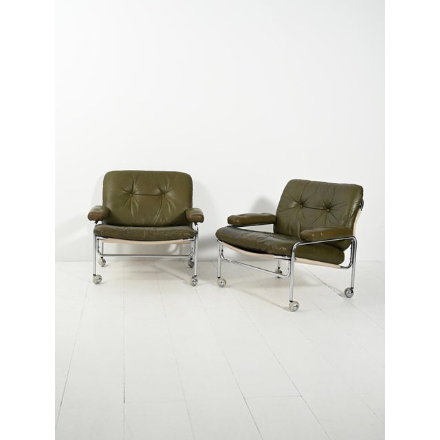 Pair of "Lovisa" armchairs from the 1970s, featuring curved chrome tubing and raw cotton, with olive green leather tufted...