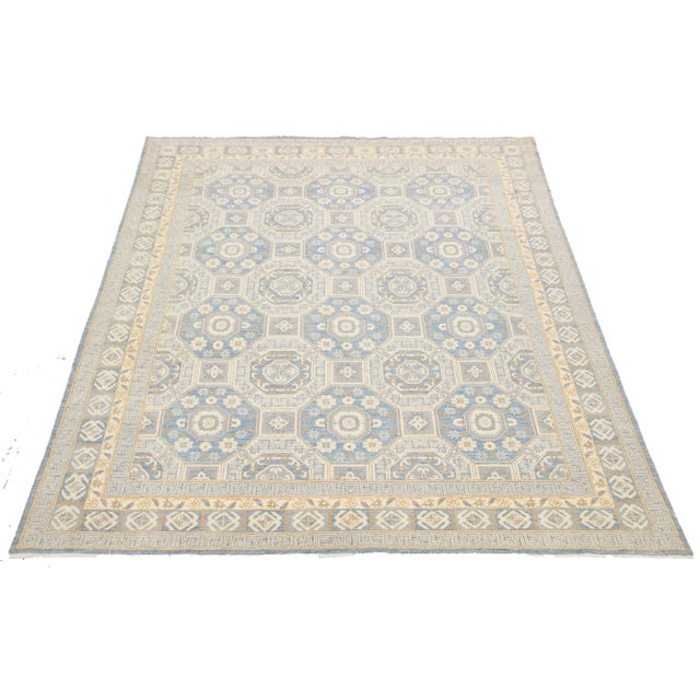 This contemporary Oushak-style wool rug showcases traditional craftsmanship. It features a striking blue background...