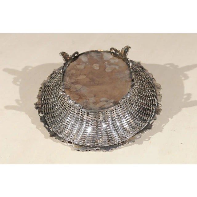 An English silverplate pierced bread basket from the 19th century, with vine and wreath motifs. Born in England during the...