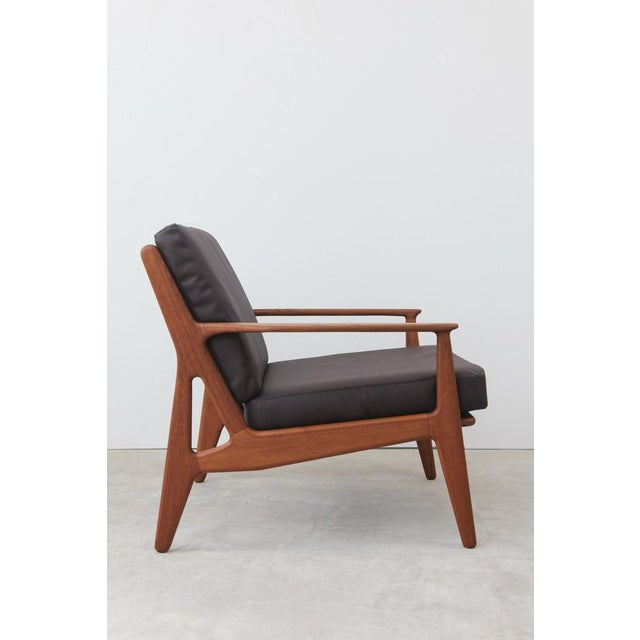 Stylish Danish vintage lounge chair by Arne Vodder. The solid teak frame is exquisitely crafted, and the chair looks...