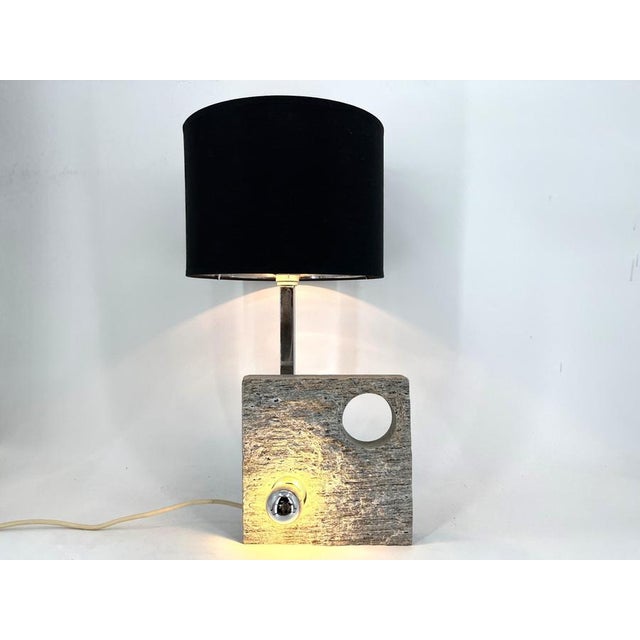 Post modern design table lamp made from a granite stone piece, with an integrated light bulb, chromed metal rod and a...