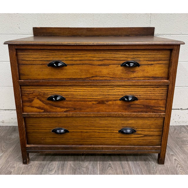 This is a stunning antique Arts and Crafts Mission-style oak dresser or chest dating to the early 1900s. It features three...