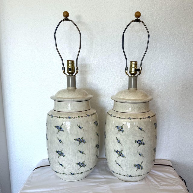 A matching pair of large vintage ceramic table lamps designed in the style of traditional covered ginger jars. The bases...