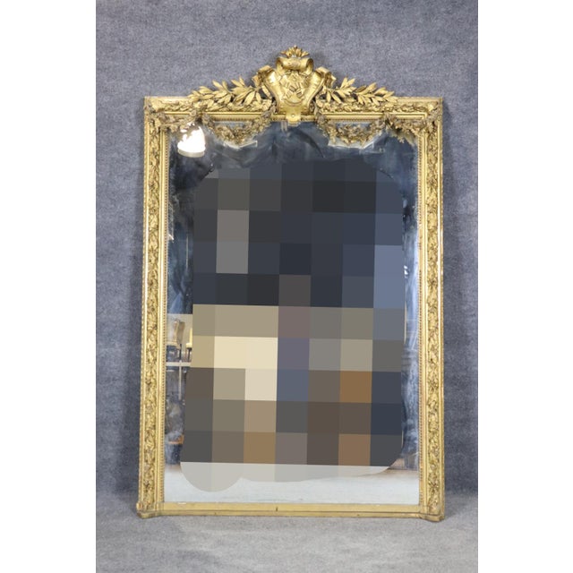 This magnificent monumental French giltwood mirror is a striking example of the grandeur and sophistication that defined...