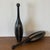 Pair of vintage sculptural turned wood clubs featuring an elongated form with contrasting brass inlay details. Their...