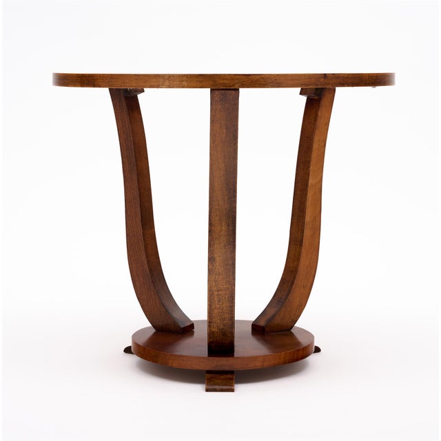 Side table from the Art Deco period in France. This piece has three curved legs that come together at the base. It is made...