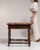 This 19th century Renaissance side table from France is finished in brown, worked in wood. Its design carries the...