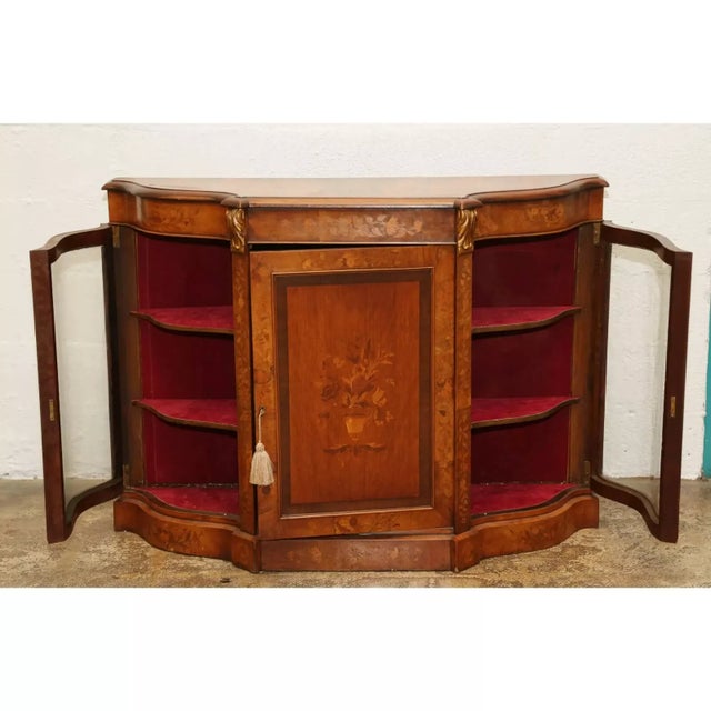 Crafted with the charm of yesteryear, this antique walnut English credenzers cabinet is a timeless addition to any space....