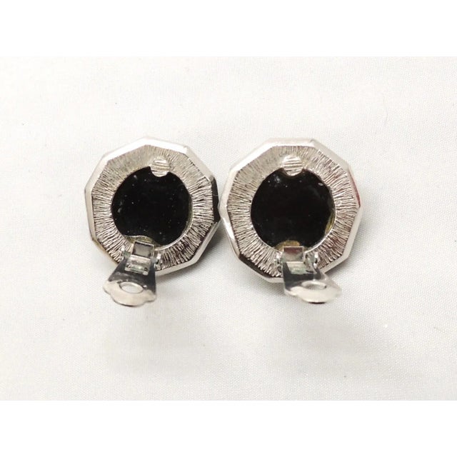 This is part of Chairish’s Costume Jewelry assortment. 1980s nonagon shaped rhodium plated faceted faux-onyx center with...