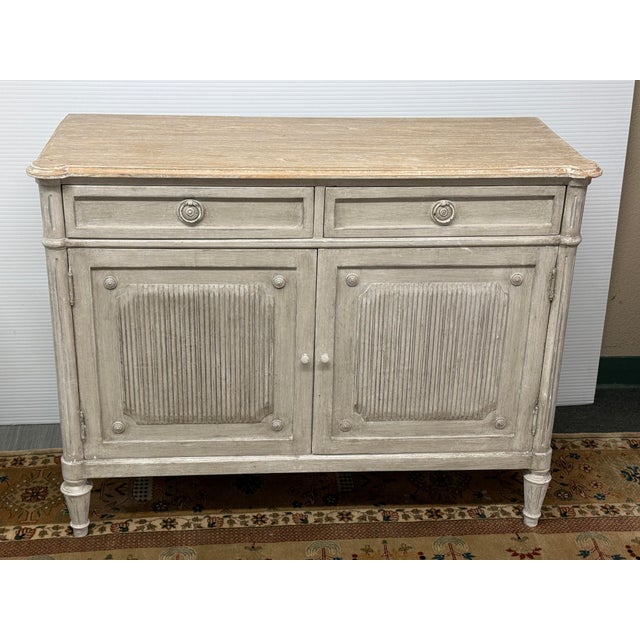 Design Plus Gallery presents a Gustavian Inspired Swedish Gray Sideboard. The piece is crafted in p8ine wood with two...