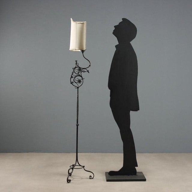 Wrought iron floor lamp featuring a stem embellished with a twisted central section and decorative details including...