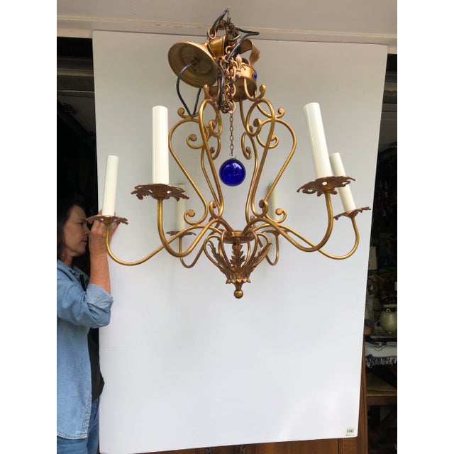 Beautiful giltiron 6 arm chandelier having an English regal vibe with bejeweled crown "coronet" at the top and cobalt blue...
