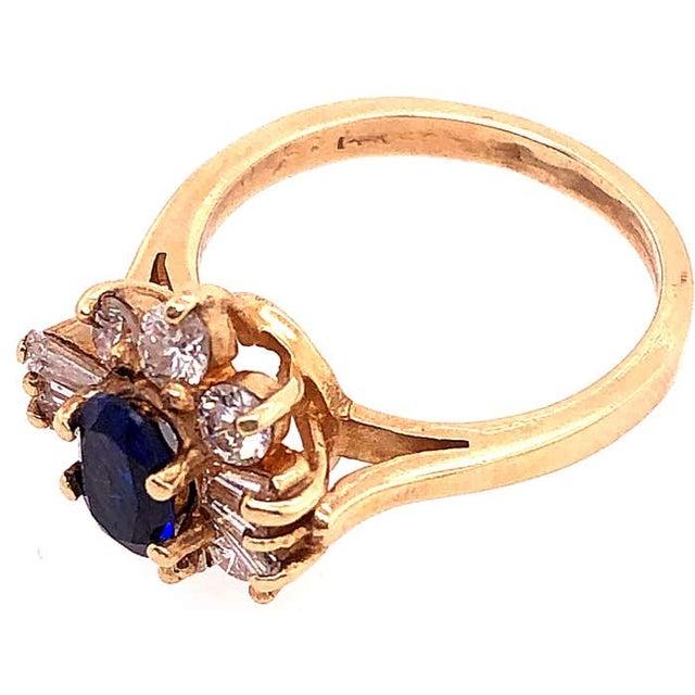 14 Karat Yellow Gold Fashion Ring with Blue Sapphire and Diamonds. 0.60 total weight of round diamonds 0.50 total weight...