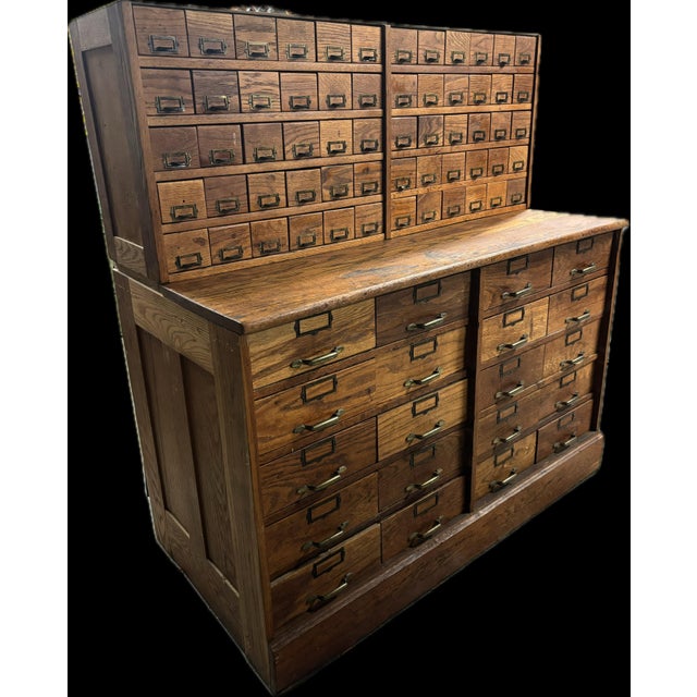 Antique oak hardware and tool cabinet with galvanized steel drawers and brass pulls with label holders. Bottom: 50 inches...