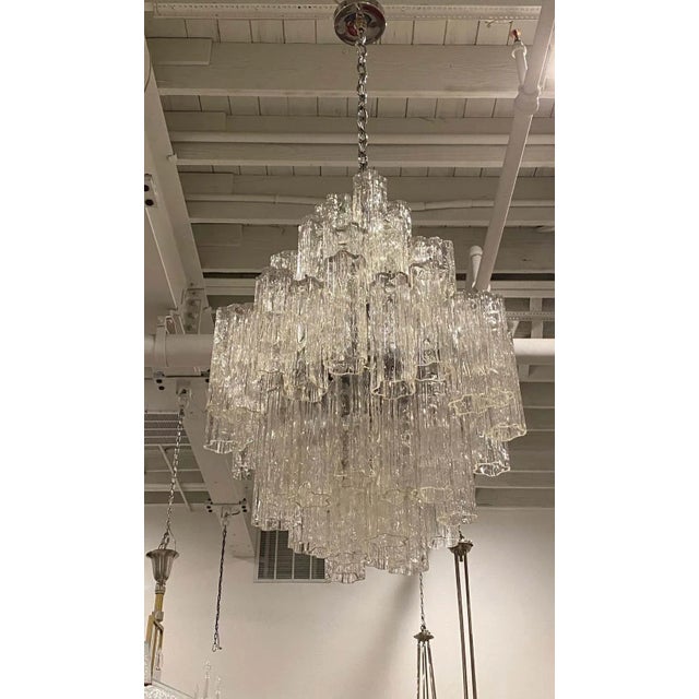 Mid-Century Modern tiered round chandelier. Consisting of tronchi cylindrical glass pieces. Each piece is hand blown and...