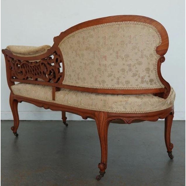 This exquisitely carved Victorian conversation settee captures the romantic elegance and craftsmanship of the late 19th...