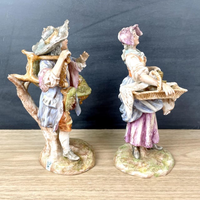 Pair of vintage Albert Stahl figurines, made in Germany. He's a furniture mender, carrying his chairs that need legs...
