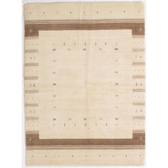 Hand-knotted Gabbeh rug featuring a soft ivory field with a structured border and scattered small-scale geometric and...