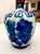 A study in timeless elegance, this substantial blue and white porcelain ginger jar is wrapped in a lush, hand-painted...