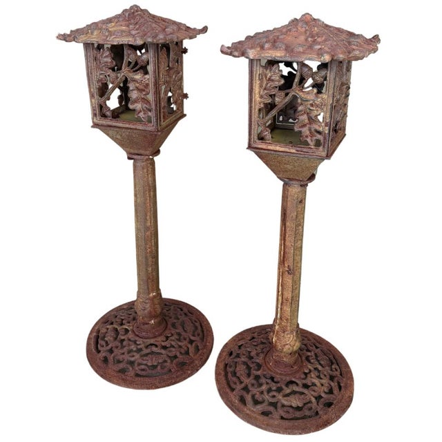Pair of mid to late 20th century cast iron outdoor pedestal garden lanterns with beautiful acorns and oak leaves. They are...