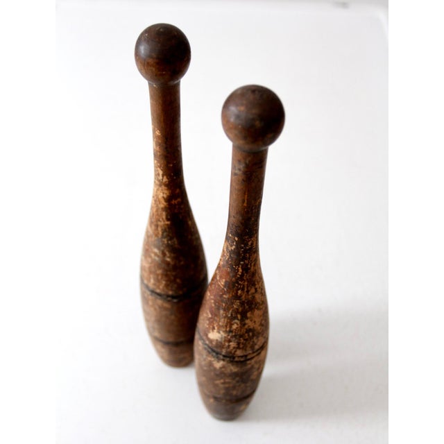 This pair of antique Indian clubs, also known as juggling pins, features a slender silhouette with a beautiful patina...