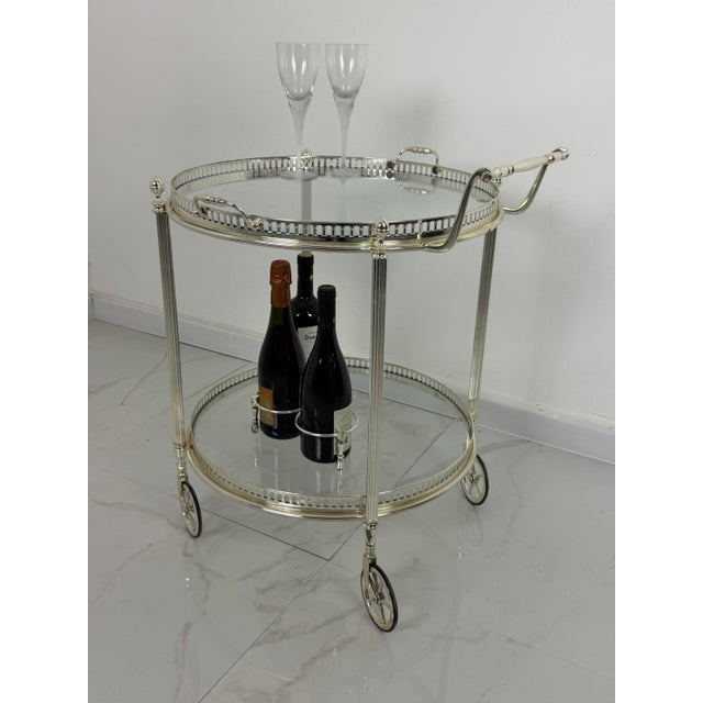 Mid-century circular chromed brass bar cart, 1960s 4 swivel casters. Removable top tray. Glass shelves. Diameter 56 cm...