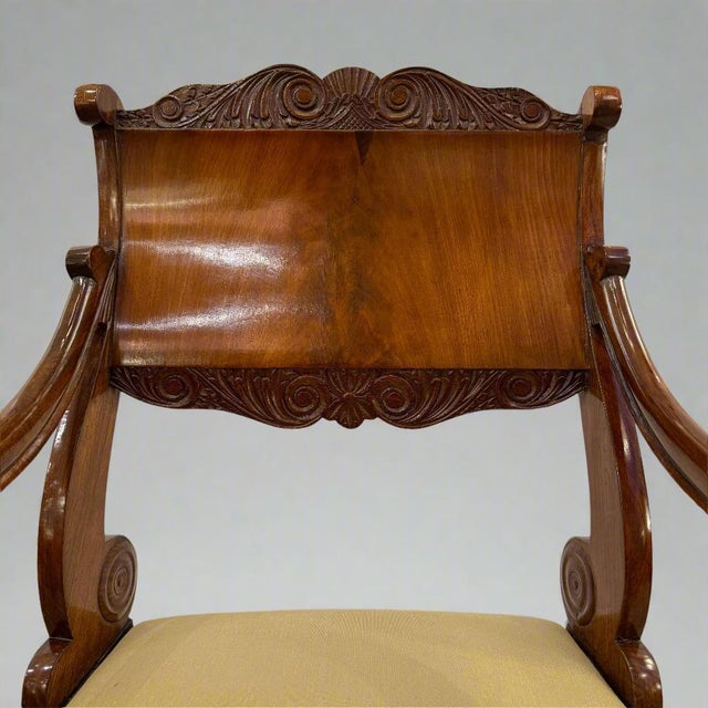 A fine Neoclassical armchair. Beautiful hardwood with carved details.