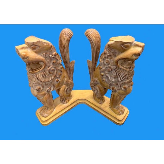A traditional East Asian architectural and temple guardian motifs Chinese lions or “foo dogs”console table. Two opposing...