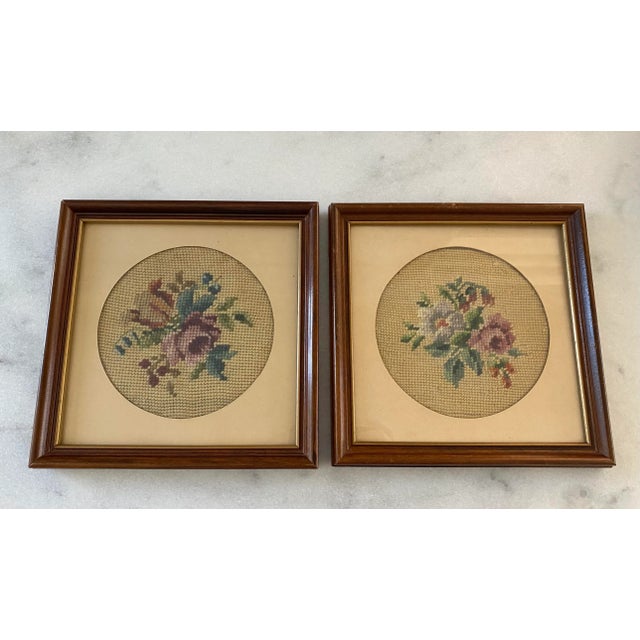 Set of 2 vintage floral needlepoint framed in brown wood frame with gold interior trim. Hand stitched needlepoint have tan...