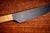 This knife made by Carl Auböck has a straight metal blade with a handle wrapped in rattan for grip. Its design is simple...